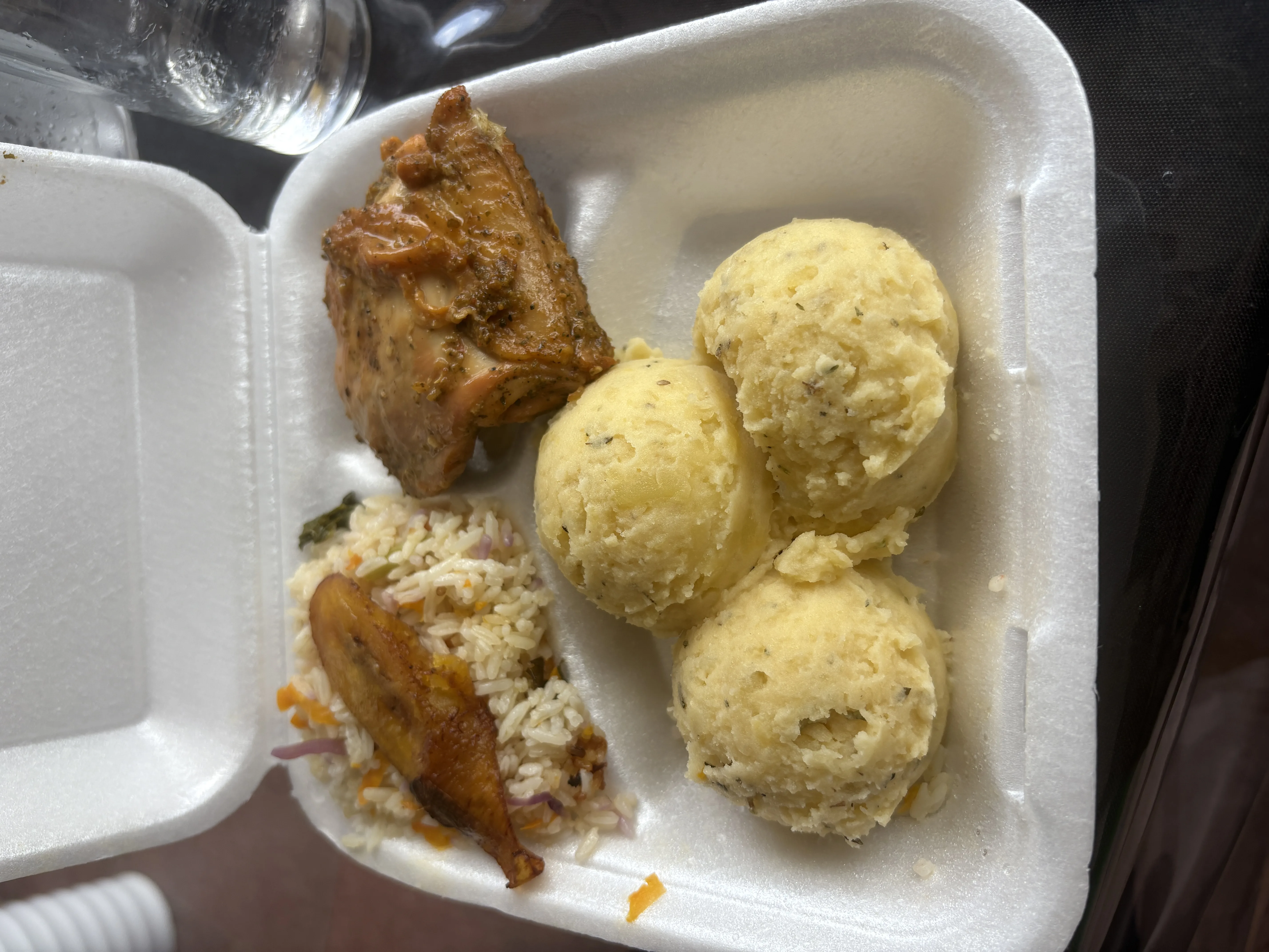 Caja para llevar con pollo, arroz, plátano y porciones de puré.