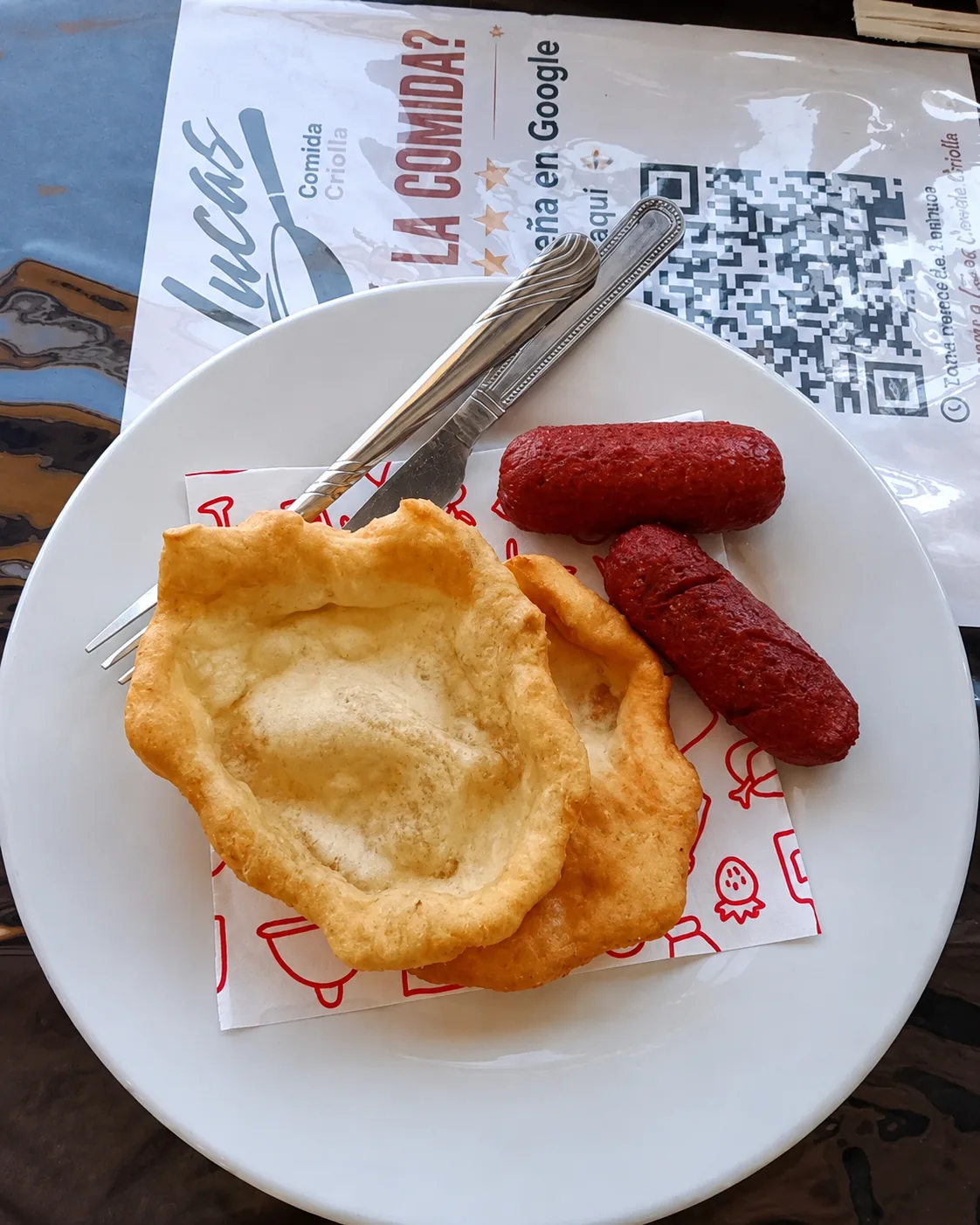 Dos piezas de masa frita con salchichas en un plato blanco.